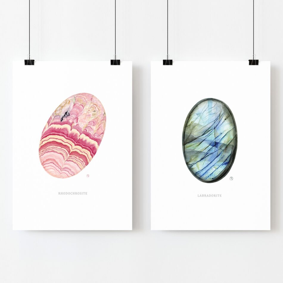 Duo de cartes postales représentant des minéraux de collection labradorite et rhodochrosite suspendues par des pinces métalliques noires sur fond blanc