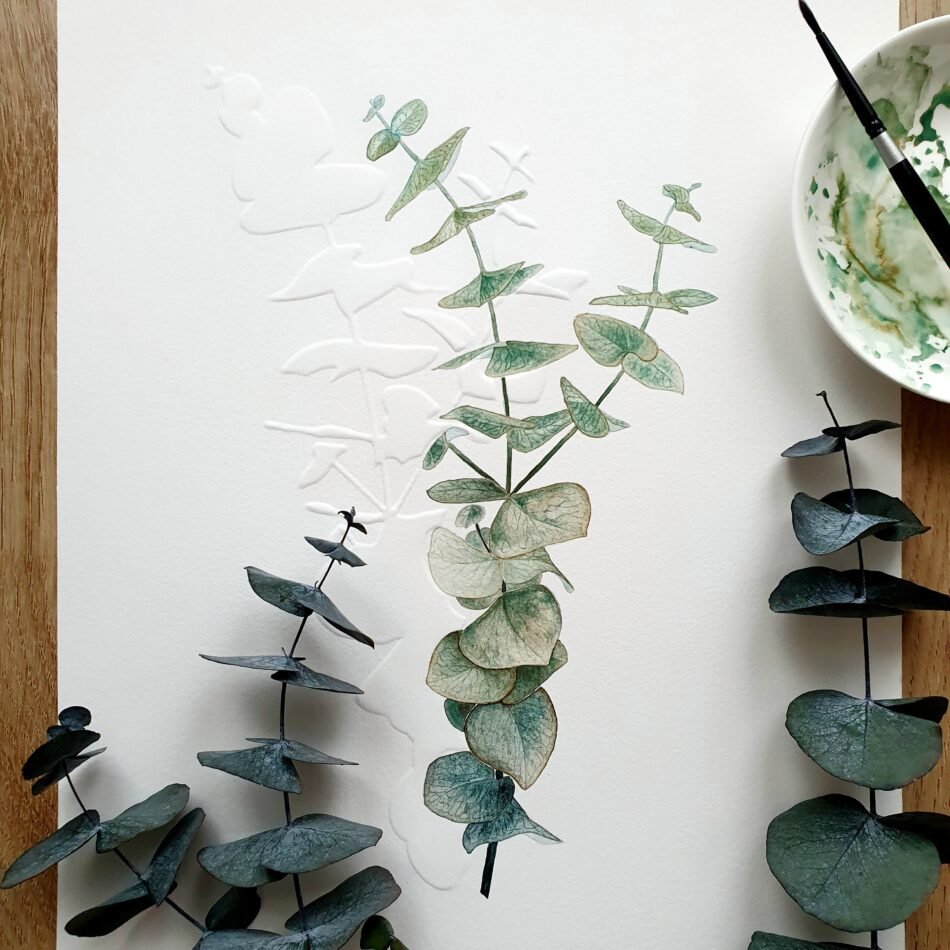 Mise en situation d'une aquarelle originale représentant une branche d'eucalyptus peinte à l'aquarelle et ombre portée sur papier embossé